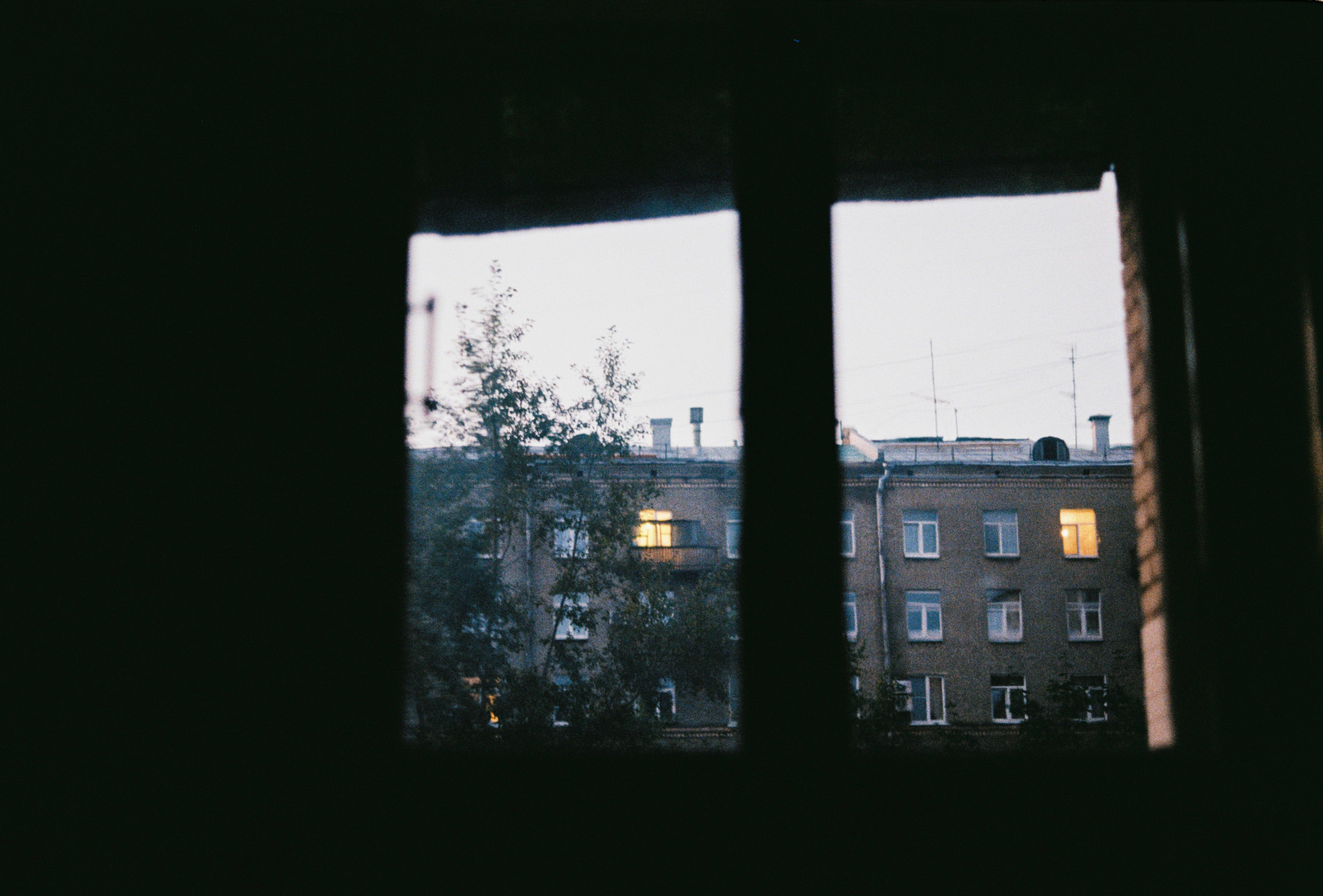 Fotografie eines Wohnhauses aus einem Fenster heraus.